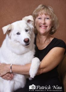 Woman smiling and holding her large white dog