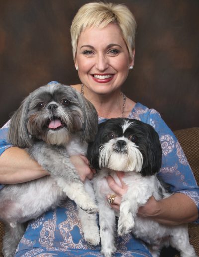 Woman smiling and holding her two dogs