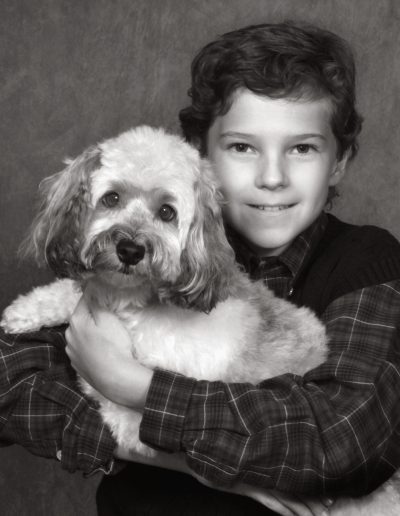 Black and white photo of a boy holding his dog