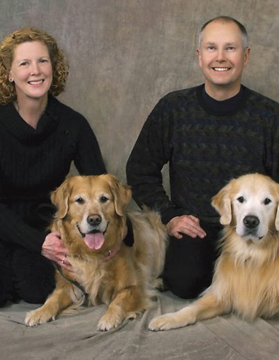 couple with their pet dogs - Golden Retrievers